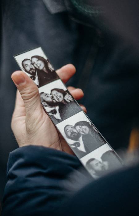 Guest holding a black and white photo booth strip
