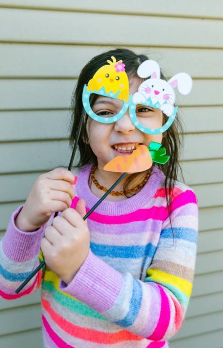 Girl wearing fun photo booth props and glasses