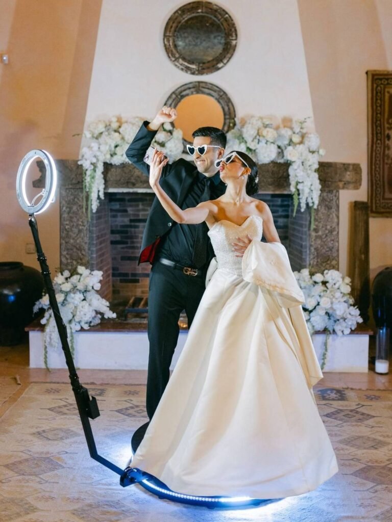 Bride and groom on a 360 photo booth platform at their wedding