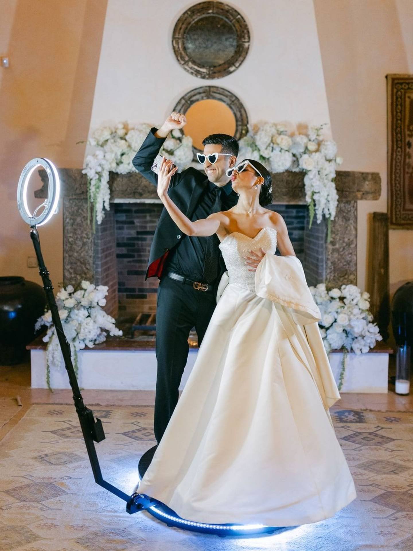 Bride and groom on a 360 video photo booth at their wedding