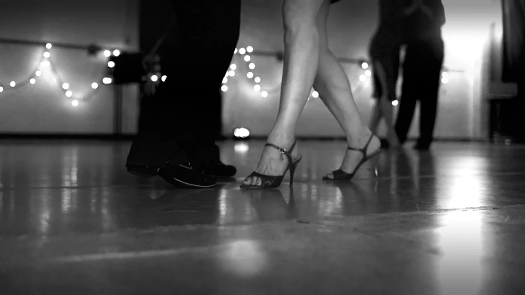 Couple dancing under string lights at a party
